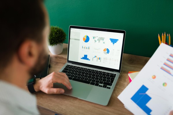 Effortlessly Monitor Sales in Real Time Business Owner Analyzing Sales Reports and Performance Metrics on a Laptop