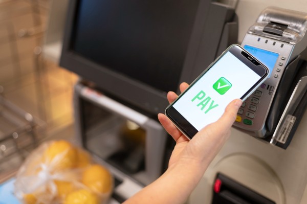 Enhanced Contactless Payment Security Measures A Person Using a Smartphone to Make a Contactless Payment at a Supermarket Checkout Terminal