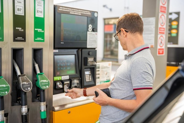 Instant Money Transfer With Credit Cards A Man Inserting a Card into a Payment Terminal at a Fuel Station