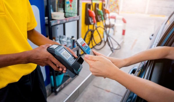 Seamless Integration with Payment and POS Systems A Customer Making a Contactless Card Payment at a Gas Station While Sitting in a Car