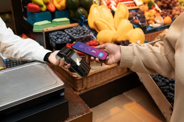 A Customer Makes a Contactless Payment Using a Smartphone at a Grocery Store Checkout Counter