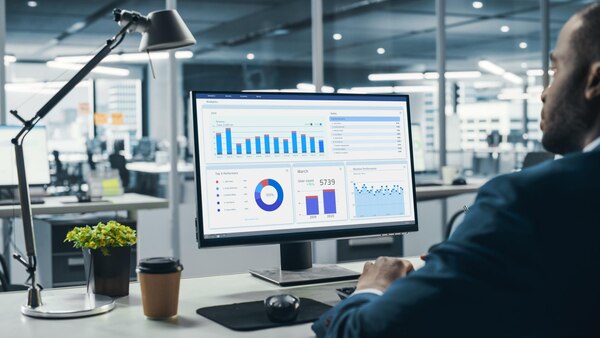Store Manager Analyzing Predictive Analytics on a Large Screen in a Convenience Store